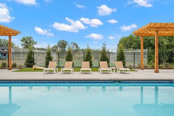 the swimming pool at our apartments with a pool and lounge chairs